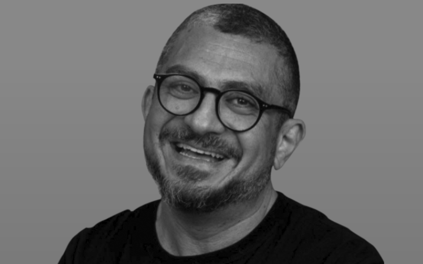 Homem com terno e fones de ouvido ouvindo um rádio antigo